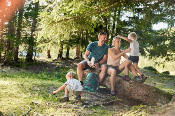 Eine Familie mit 2 Kindern machen beim Wandern in Altenmarkt-Zauchensee gerade eine kurze Pause