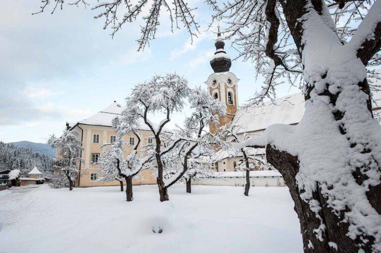 Blick auf die Kirche in Altenmarkt mit verschneiten Bäumen im Vordergrund