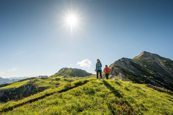 Zwei Wanderer bei strahlenden Sonnenschein auf einer Wanderroute in den Bergen rundum Altenmarkt-Zauchensee